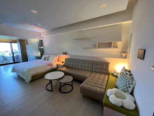 um quarto com um sofá e uma cama e uma cama e uma mesa em 漫遊文旅溫泉宅ㄧ山海景觀陽台房ㄧ晚上6點入住ㄧ晚進晚退一21小時睡飽飽方案 em Toucheng