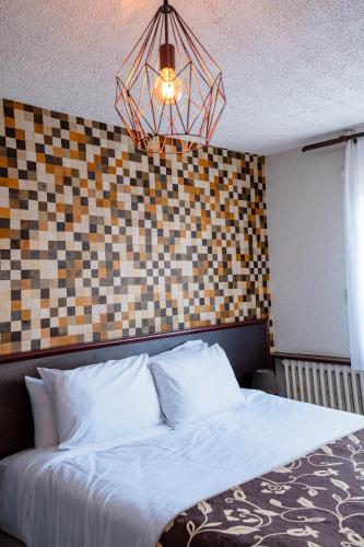 a bedroom with a bed with a checkerboard wall at Logis Hôtel Le Bellevue in Trévignin
