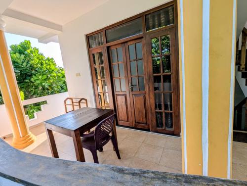 a room with a wooden table in front of a door at Costels Coconut hill in Mirissa
