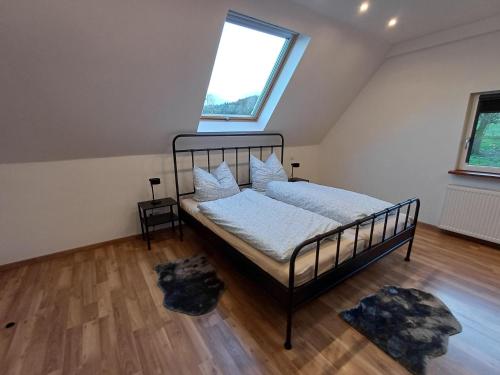 ein Schlafzimmer mit einem Bett mit weißen Laken und einem Fenster in der Unterkunft Ferienwohnung Beim Schorsch in Schannenbach