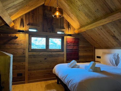- une chambre avec un grand lit dans une cabane en bois dans l'établissement Mazot de la Pointe Percée, à Demi-Quartier