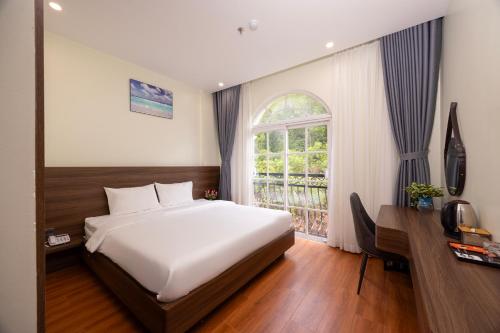a bedroom with a large bed and a window at Hồng Chúc Hotel in Phú Quốc