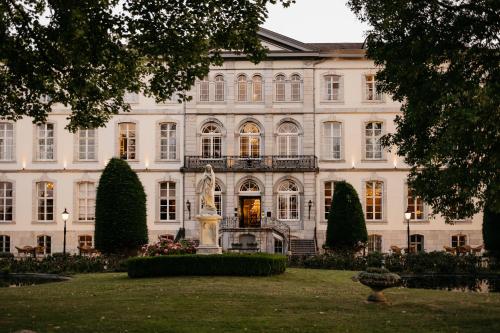 a large white building with a statue in front of it at Hotel Bloemendal, near Aachen in Vaals