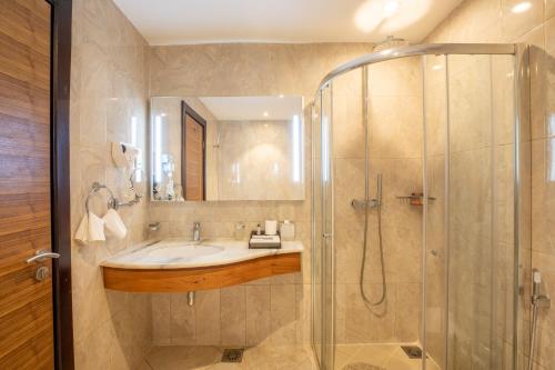 ein Badezimmer mit Waschbecken und Dusche in der Unterkunft Golden Tulip Canaan Kampala in Kampala