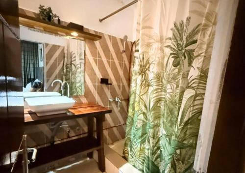 a bathroom with a shower curtain and a sink at Retreat Cameroon BASTOS in Yaoundé