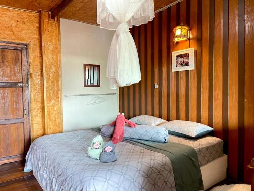 a bedroom with two beds with stuffed animals on them at Bankruchaem Homestay Kohpu in Ban Klang