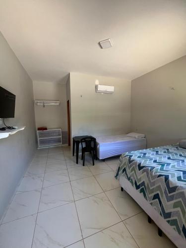 a bedroom with a bed and a table in it at Pousada Rancho do Cometa in Ubajara