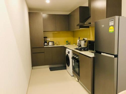 a small kitchen with a refrigerator and a stove at Fairway Galle in Galle