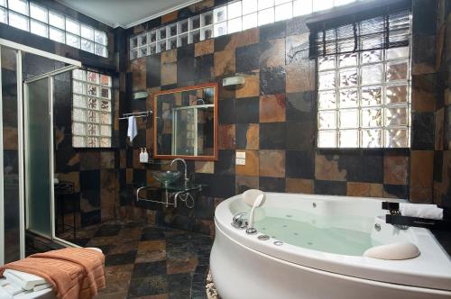 a bathroom with a large tub and a window at The Nai Harn Collective in Rawai Beach