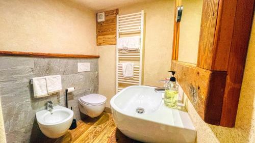 a bathroom with a tub and a toilet and a sink at Borgo Felice Fontana - Affitti Brevi Italia in Monfol