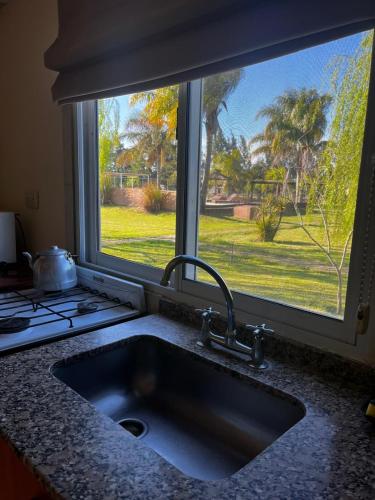 a kitchen sink with a large window above it at Cabañas Las Primorosas in Cañuelas
