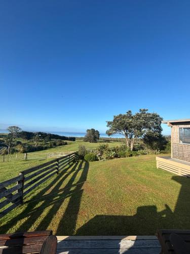 a view from the porch of a house with a fence at Rangiputa Retreat in Karikari Peninsula
