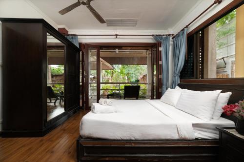 a bedroom with a large bed and a balcony at The Nai Harn Collective in Rawai Beach