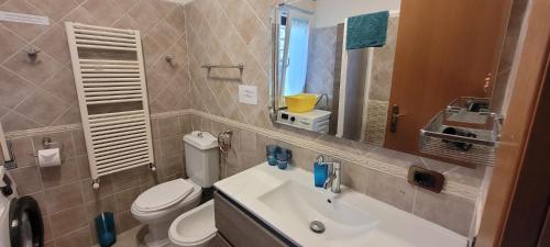 a bathroom with a sink and a toilet and a mirror at Travel Solution - Seaview & Roman Apartments in Anzio