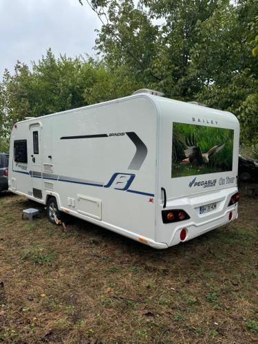 a white rv parked in a field at Caravana dintre nuci in Oradea