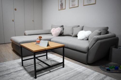 een woonkamer met een bank en een tafel bij WRW Airport Residence in Otopeni
