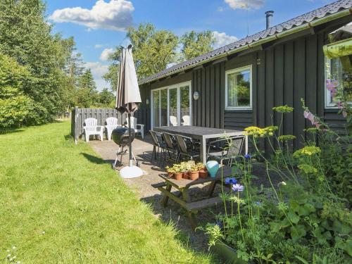 Ørstedにある8 person holiday home in Ørstedの庭のテーブルと傘を持つ家