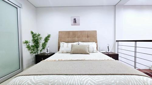 a bedroom with a large bed in a white room at Nautica 009 Studio Flat in Mossel Bay