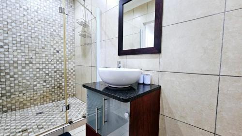 a bathroom with a sink and a mirror at Nautica 009 Studio Flat in Mossel Bay