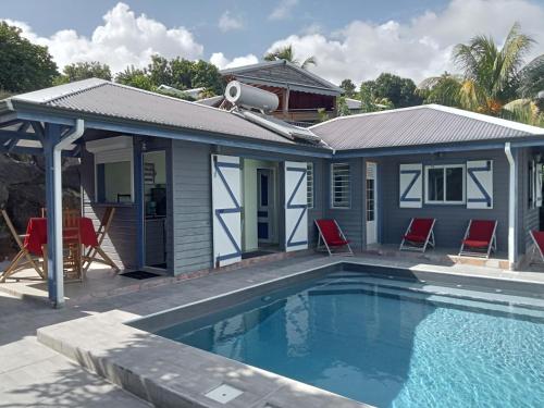 三河市AWMONY'KAZ, Gite à Trois-Rivières GUADELOUPE的一栋前面有游泳池的房子