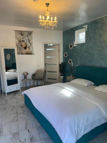 a bedroom with a large bed and a chandelier at Popasul Castelului in Hunedoara