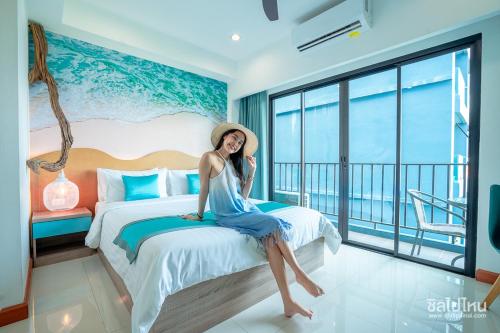 een vrouw op een bed in een hotelkamer bij Jomtien Beach Market Place in Jomtien Beach