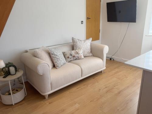 a living room with a couch with pillows on it at Sunny Bright Flat near South Park and OxfordBrooks in Oxford