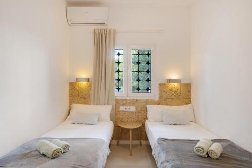 Dos camas en una habitación con ventana. en Villa Montecristo, en Montecristo