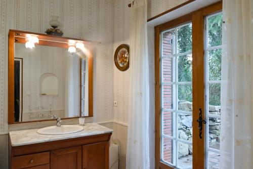une salle de bain avec un lavabo, un miroir et une fenêtre dans l'établissement Le BASTIDON de CHANTE PIERRE, à Cuers