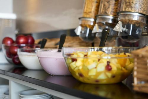 a counter with bowls of fruit on a table at Four Points Flex by Sheraton Brighton in Brighton & Hove