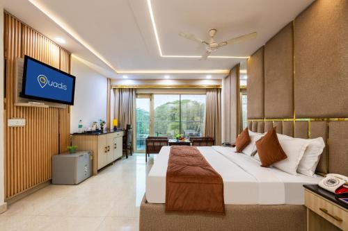 um quarto de hotel com uma cama e uma TV em Hotel Downtown - East of Kailash em Nova Deli