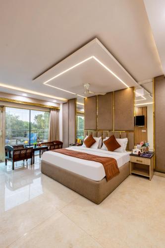 a large bedroom with a large bed and a desk at Hotel Downtown by Quadis - East of Kailash in New Delhi