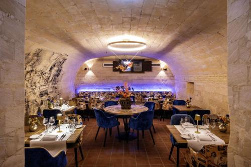un restaurant avec des tables et des chaises dans une salle avec un mur en pierre dans l'établissement Hotel Kasteel Oost, à Fauquemont
