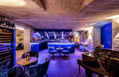 un bar avec des chaises et des tables bleues dans une pièce dans l'établissement Hotel Kasteel Oost, à Fauquemont
