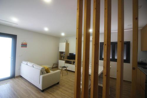 a living room with a white couch and a television at Quinta da Lagoa - Gerês in Terras de Bouro