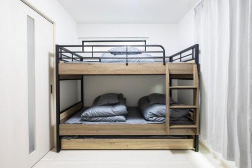 a bunk bed with pillows on it in a room at Villetta Imari Ekimae III Room 104 - Vacation STAY 19028 in Imari