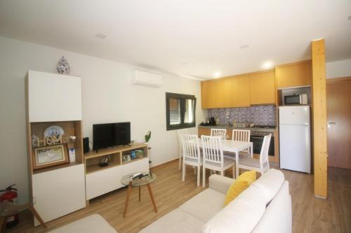 a living room with a white couch and a kitchen at Quinta da Lagoa - Gerês in Terras de Bouro
