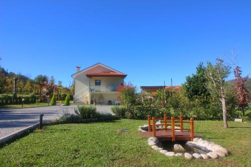 a bench in the grass in front of a house at Quinta da Lagoa - Gerês in Terras de Bouro