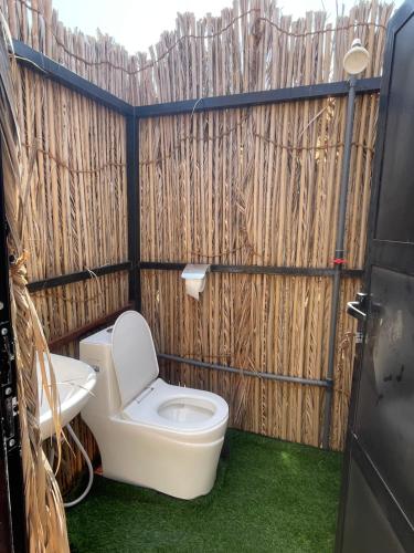 baño con aseo y valla de madera en Mirage Desert Camp, en Al Raka