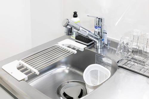 a kitchen sink with a dish drying rack next to it at Villetta Imari Ekimae III Room 103 - Vacation STAY 19026 in Imari