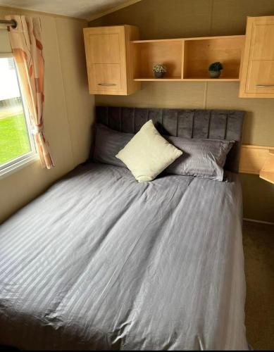 a large bed in a small room in a caravan at Caravan by the Sea KW10 in Kinmel Bay