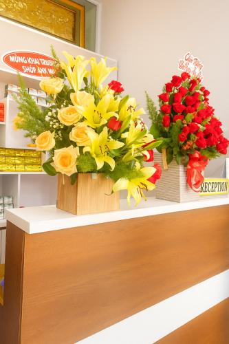 two bouquets of yellow and red flowers on a counter at Ánh Mai Hotel in Bảo Lộc