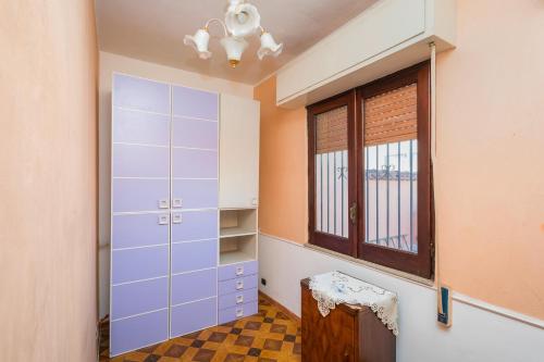 a dressing room with a blue cabinet and a window at A Casa Mia in Riposto