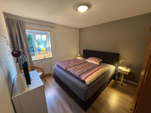 ein kleines Schlafzimmer mit einem Bett und einem Fenster in der Unterkunft DünenZeit in List