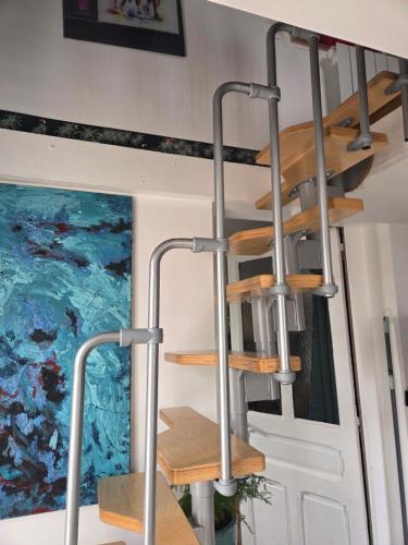 une cage d'escalier dans une pièce avec des étagères en bois dans l'établissement Chez damdam et titi, à Dijon