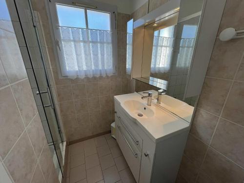 a bathroom with a sink and a mirror and a shower at LOIZEAU - Maison 2 chambres in Ars-en-Ré
