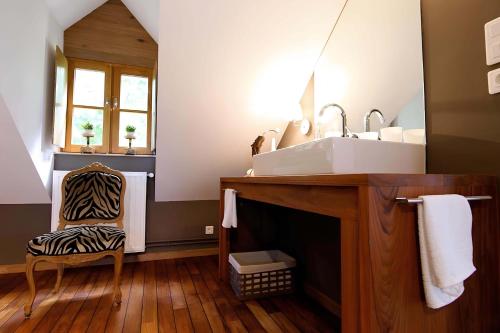 a bathroom with a sink and a zebra print chair at Comme une parenthèse au coeur des hortillonnages in Amiens