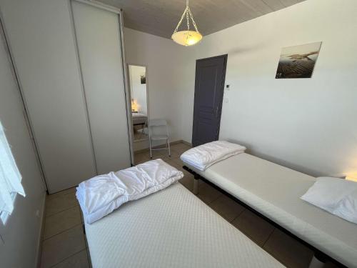 two twin beds in a room with a table at Loizeau 3 chambres in Ars-en-Ré