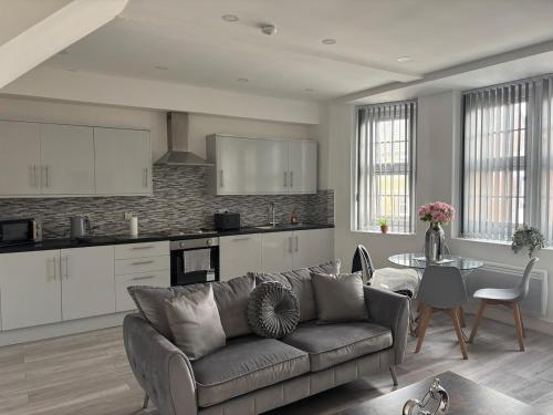 a living room with a couch and a kitchen at Modern and Spacious Home CITY CENTRE location and FREE parking in Bolton