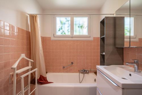 a bathroom with a white tub and a sink at Charmante maison familiale Mandelieu-la-Napoule in Mandelieu-la-Napoule